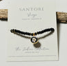 Black beaded zodiac bracelet with a gold and black virgo charm on a Santore branded card.